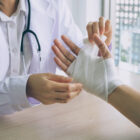 The,Doctor,Is,Treating,The,Injured,Hand,Patient,With,A