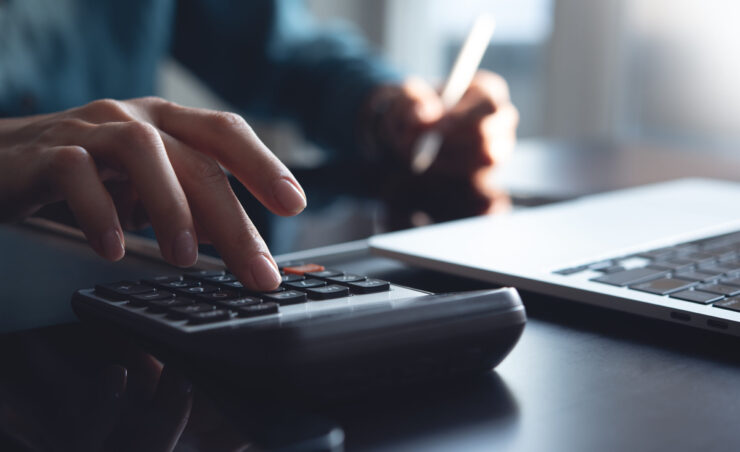 Accountant using calculator to calculate company finances at office. Bookkeeper inspector calculated and checking balance account. accounting and auditing, budget and tax calculation